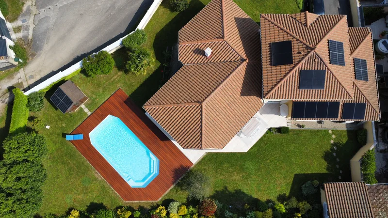 Vue du ciel d'une maison équipée, la piscine au pied du toit